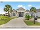 Stunning home exterior with palm trees, a circular driveway and meticulously landscaped front yard at 202 Ave. Of The Palms, Myrtle Beach, SC 29579