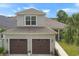 Spacious two-car garage with brown doors and an apartment above, offering ample parking and living space at 202 Ave. Of The Palms, Myrtle Beach, SC 29579