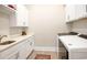 Well-lit laundry room featuring modern washer/dryer, ample cabinets, and a sleek countertop with a built-in sink at 202 Ave. Of The Palms, Myrtle Beach, SC 29579