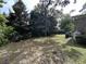 Grassy backyard with scattered leaves, a propane tank, and mature trees along the property line at 902 N 11Th Ave. N, North Myrtle Beach, SC 29582