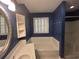 Bathroom with blue walls, white tiling, and an oval mirror at 902 N 11Th Ave. N, North Myrtle Beach, SC 29582