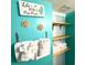 Light bathroom with white towels, wood shelves, and a beach-themed sign at 5905 S Kings Hwy. # 231, Myrtle Beach, SC 29577