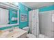 Bright bathroom featuring blue walls, a shower with a fish-themed curtain, and a white vanity with sink at 5905 S Kings Hwy. # 231, Myrtle Beach, SC 29577