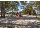Spacious playground with multiple slides and play structures amidst mature trees and a sandy base at 5905 S Kings Hwy. # 231, Myrtle Beach, SC 29577