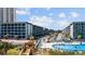 Community offers a pool with lounge chairs and a boardwalk bridge near multi-story accommodations at 5905 S Kings Hwy. # 231, Myrtle Beach, SC 29577