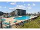 Outdoor pool area with many lounge chairs and a view of the condo building at 5905 S Kings Hwy. # 231, Myrtle Beach, SC 29577