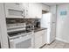 Compact kitchen with white appliances, updated backsplash, and granite counters at 6900 N Ocean Blvd. # 405, Myrtle Beach, SC 29572