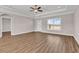 Spacious living room showcasing wood flooring, a tray ceiling with a ceiling fan, and large windows for natural light at 107 Deans Ct., Green Sea, SC 29545