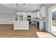 Open concept living room showing the kitchen and dining area with ample sunlight shining through sliding glass doors at 107 Deans Ct., Green Sea, SC 29545