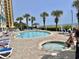 Outdoor pool area with lounge chairs for relaxing and a separate in-ground hot tub at 2504 N Ocean Blvd. # 734, Myrtle Beach, SC 29577