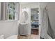 Bathroom featuring a vanity, sink, lighting, and window, leading to a glimpse of the adjacent bedroom at 412 29Th Ave. N, Myrtle Beach, SC 29577