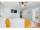 Bright bedroom featuring light blue walls, ceiling fan, TV, and bed with white linens and orange pillows at 412 29Th Ave. N, Myrtle Beach, SC 29577