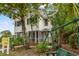 Charming white two-story home featuring a screened-in porch and lush greenery at 412 29Th Ave. N, Myrtle Beach, SC 29577