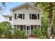 Two-story home with white siding, a screened in porch, and lush landscaping at 412 29Th Ave. N, Myrtle Beach, SC 29577