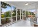 Comfortable screened porch with wicker furniture, offering a relaxing view of the lush, landscaped yard at 412 29Th Ave. N, Myrtle Beach, SC 29577