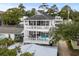 Two-story white house with black shutters and multiple decks, surrounded by lush trees at 6001 - N14 S Kings Hwy., Myrtle Beach, SC 29575