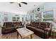 Comfortable living room featuring brown leather sofas, ceiling fan, and beach decor under large windows at 6001 - N14 S Kings Hwy., Myrtle Beach, SC 29575