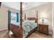 Spacious main bedroom featuring a four-poster bed, ceiling fan, and natural light at 6001 - N14 S Kings Hwy., Myrtle Beach, SC 29575