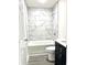 Bright bathroom featuring a white tub with marble-look tiling at 6306 Somerset Dr., Myrtle Beach, SC 29572