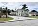 A townhome showcasing a light green and white color scheme, sidewalks, and a spacious parking lot at 6306 Somerset Dr., Myrtle Beach, SC 29572