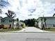 Shot of townhomes exhibiting lawns with young palm trees, well-kept landscaping, and a paved parking area at 6306 Somerset Dr., Myrtle Beach, SC 29572