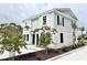 Shot of a townhome with white brick, black shutters, and neat landscaping in front of a paved parking area at 6306 Somerset Dr., Myrtle Beach, SC 29572