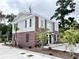 Exterior townhome featuring brick and siding with black shutters, landscaping, and a paved parking area at 6306 Somerset Dr., Myrtle Beach, SC 29572