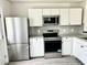 Sleek kitchen featuring stainless steel appliances, white cabinets, granite countertops, and subway tile backsplash at 6306 Somerset Dr., Myrtle Beach, SC 29572