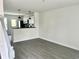 A well-lit living room with light gray vinyl floors and opening into a kitchen with black appliances and countertops at 6306 Somerset Dr., Myrtle Beach, SC 29572