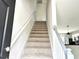 Bright, carpeted staircase leading to the upper level of the home, offering a seamless transition between floors at 6306 Somerset Dr., Myrtle Beach, SC 29572