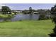 Backyard view featuring a large pond surrounded by trees and a well-maintained lawn at 4290 Pinehurst Circle # B6, Little River, SC 29566