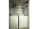 Laundry room featuring a stacked white washer and dryer with shelving above for storage at 4290 Pinehurst Circle # B6, Little River, SC 29566