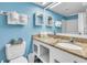 Bathroom with granite countertop, white cabinets, mirror and blue walls at 1207 S Ocean Blvd. # 20604, Myrtle Beach, SC 29577