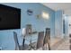 Dining area with glass table, leather chairs, tv and blue walls at 1207 S Ocean Blvd. # 20604, Myrtle Beach, SC 29577