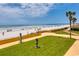 Enjoy the expansive beach view with palm trees, complemented by a lush lawn area at 9650 Shore Dr. # 1805, Myrtle Beach, SC 29572