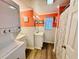 Bathroom featuring a washer/dryer, sink with storage, window and orange accent wall at 6001 - N21 S Kings Hwy., Myrtle Beach, SC 29575