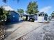 Charming blue home with a covered patio featuring yellow chairs, plus a convenient golf cart and spacious driveway at 6001 - N21 S Kings Hwy., Myrtle Beach, SC 29575