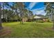 A serene backyard featuring a screened porch, lush green grass and mature trees at 3517 Golf Ave., Little River, SC 29566