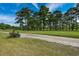 Picturesque golf course with a dirt path winding past lush green fairways and tall pines at 3517 Golf Ave., Little River, SC 29566