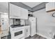 Galley kitchen features white cabinetry, white appliances and tiled backsplash at 1207 S Ocean Blvd. # 20304, Myrtle Beach, SC 29577
