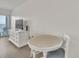 Bright living room with a white dresser, TV, table and two chairs, and a sliding glass door to a balcony at 1207 S Ocean Blvd. # 20308, Myrtle Beach, SC 29577