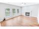 Bright living room with hardwood floors, a fireplace, ceiling fan, and three windows providing natural light at 629 Slash Pine Ct., Myrtle Beach, SC 29579