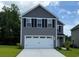 Two story home featuring gray siding, black shutters, a white garage door, and a well manicured lawn at 1055 Oak Meadow Dr., Conway, SC 29526