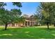 Beautiful two-story brick home with a well-manicured lawn, mature trees, and a welcoming front porch at 9325 Cove Dr., Myrtle Beach, SC 29572