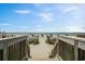 View from a boardwalk leading to sandy beach with umbrellas and ocean at 1501 South Ocean Blvd. # 644, Myrtle Beach, SC 29577