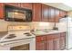 Compact kitchen features a microwave, range, double sink, and wooden cabinets at 1501 South Ocean Blvd. # 644, Myrtle Beach, SC 29577