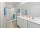 Bright bathroom features double sinks with white cabinets and a glass-enclosed shower at 1100 Commons Blvd. # 104, Myrtle Beach, SC 29572
