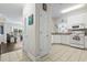 Bright kitchen featuring white cabinetry, a window over the sink, and tiled flooring, open to living area at 1100 Commons Blvd. # 104, Myrtle Beach, SC 29572