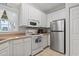 Bright kitchen featuring white cabinets, stainless steel refrigerator, and modern appliances at 1100 Commons Blvd. # 104, Myrtle Beach, SC 29572
