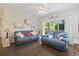 Cozy living room with comfortable blue sofas, ceiling fan, and sliding glass doors at 1100 Commons Blvd. # 104, Myrtle Beach, SC 29572
